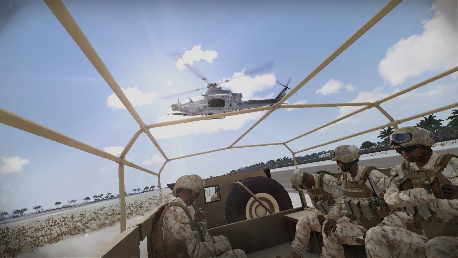 Marines riding in an open truck bed as an attack helicopter passes overhead