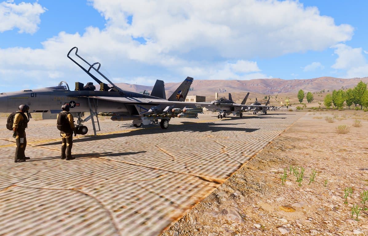 Pilots walking the flight line past armed Hornets